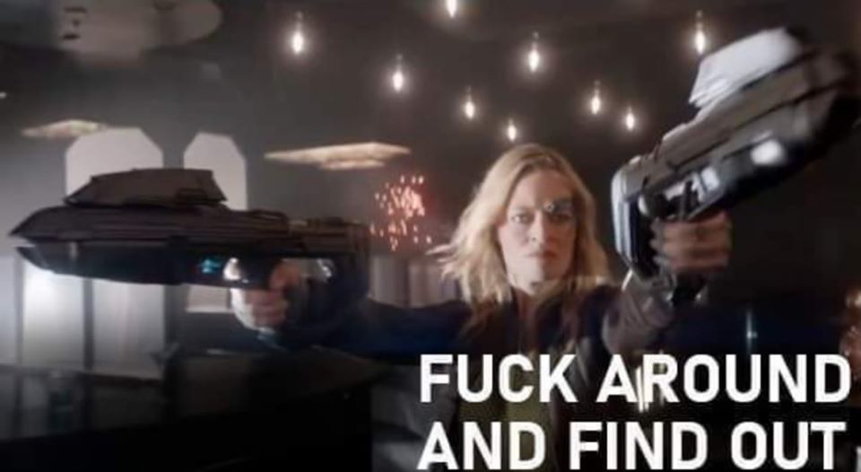 This meme is a screenshot from a Star Wars movie, specifically a scene where a character is being attacked by a group of Stormtroopers. The image shows a character (likely a Jedi) holding a lightsaber and using it to deflect a blaster shot, while another character (likely a Jedi's ally) is in the background with a shocked expression. The text overlayed on the image reads "When you find out your friend has been talking to the Empire behind your back".